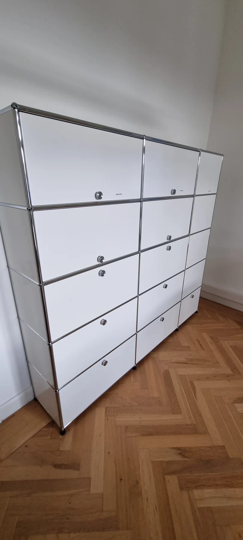 Fertig montierte weiße USM-Haller-Schrankkombination mit geschlossenen Fronten und Chromrahmen